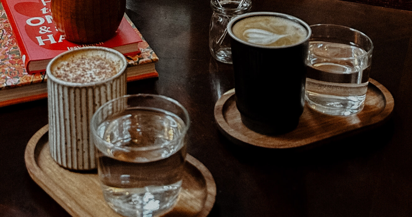 Close-up of coffee trays in The Code Austin lounge with tables for relaxing, conversation, and drinks behind the lobby.